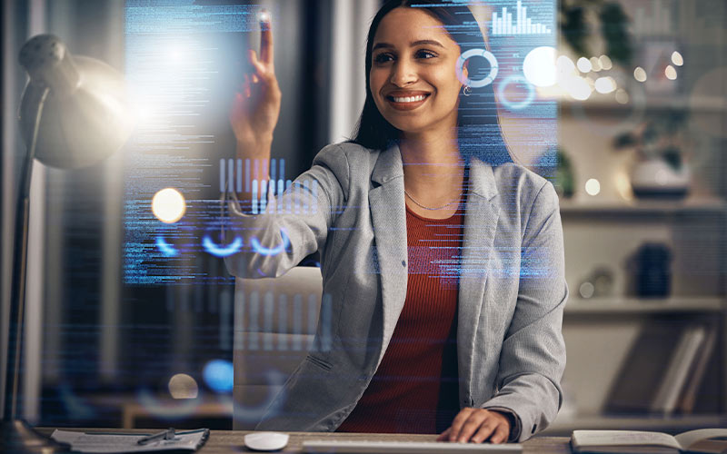 A woman using a computer with a digital interface, focused and engaged in her work.