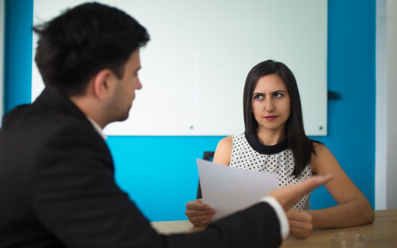 A man and woman in an office setting, working together on a project, discussing ideas and using a computer.